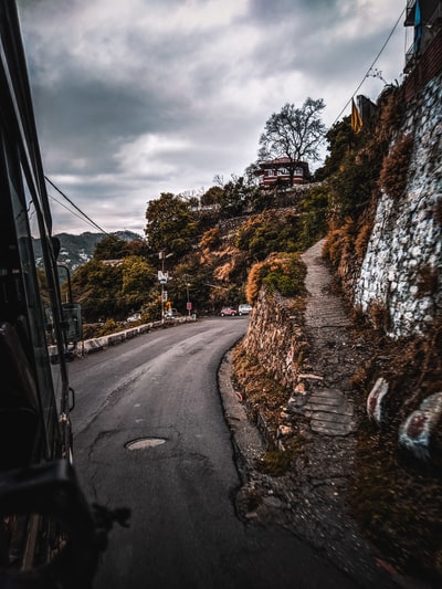 之间的灰色沥青道路树木在灰色天空多云的白天
